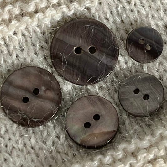 Solid perlemorsknap i en varm grå brun farve.