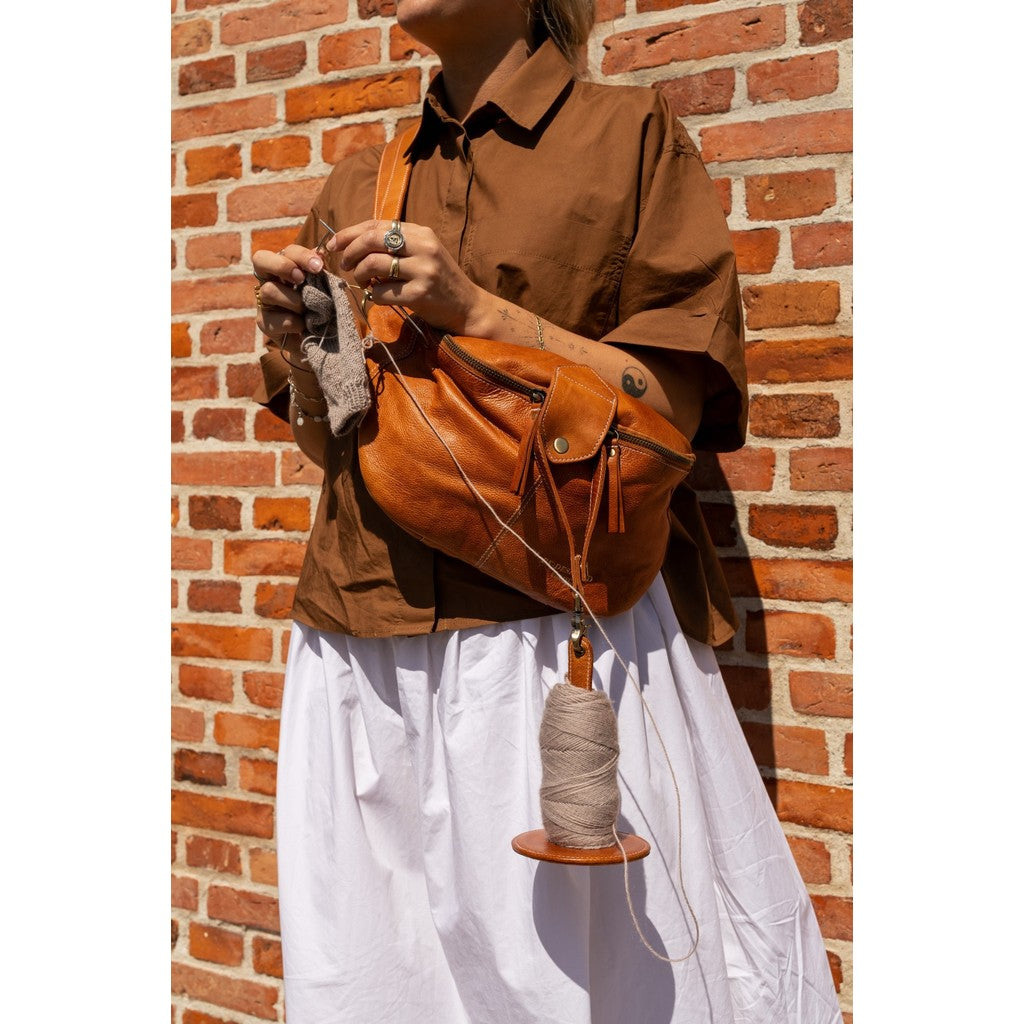 PROJECT 94 er en smart garnholder, du kan hænge på håndleddet når du strikker eller hækler gående og stående. Du kan også hænge den på din stols armlæn, når du sidder ned.